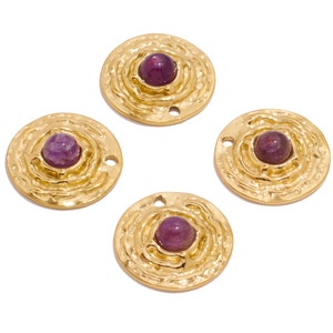 Op de afbeelding: Vier goudkleurige metalen bedels met een getextureerd oppervlak en een paarse edelsteen in het midden. Elke bedel heeft twee gaten om aan een ketting of armband te bevestigen.