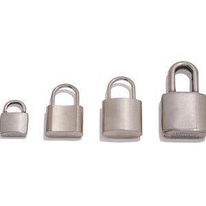 May include: Four silver-colored padlocks of varying sizes are arranged in a row against a white background. Each padlock has a rectangular body and a curved shackle. The metal has a matte finish.