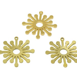 May include: Three gold metal starburst charms with a circular cutout in the center. Each charm has a loop at the top for attaching to a necklace or bracelet.