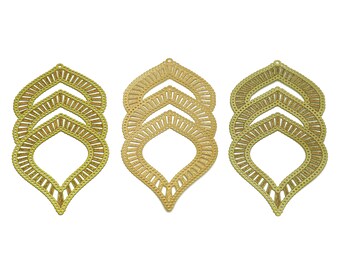 May include: Three gold metal decorative pieces with a layered, intricate design resembling a stylized leaf. Each piece has a cutout shape in the center.