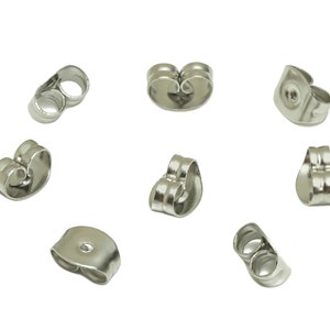 Puede incluir: Un juego de ocho respaldos para pendientes de plata. Los respaldos son de metal y tienen un acabado liso.