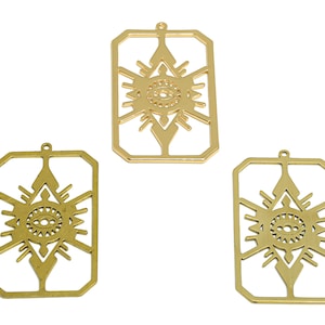 Puede incluir: Tres colgantes rectangulares dorados con un diseño geométrico. Cada colgante presenta un motivo de ojo central rodeado de líneas radiales y formas geométricas. Los colgantes tienen un pequeño lazo en la parte superior para colgar.