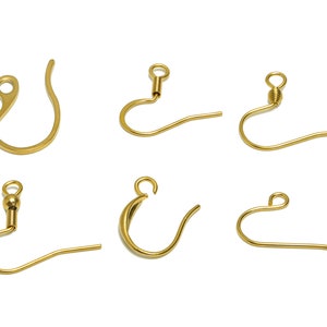 May include: Six gold-toned earring hooks, each with a different style of hook and closure. The hooks are all made of metal and are designed for use with earrings.