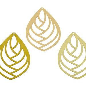 May include: Three gold leaf-shaped metal cutouts with a decorative design. The cutouts are in different shades of gold.