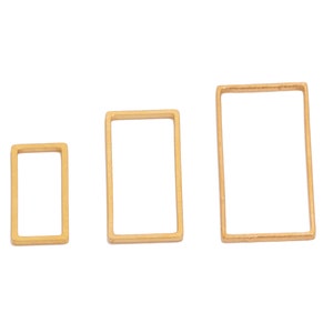 Puede incluir: Tres marcos rectangulares de metal de color dorado de diferentes tamaños.