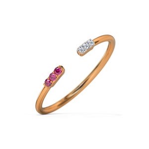 Peut inclure: Une bague en or avec un design de pierres roses et blanches. La bague est ouverte et a une bande simple.