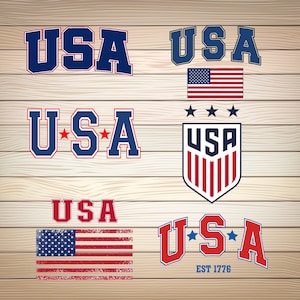 May include: A collection of six different graphic designs featuring the word "USA" in various styles. The designs include a classic red, white, and blue color scheme, a distressed American flag, and a soccer-inspired design with stars.