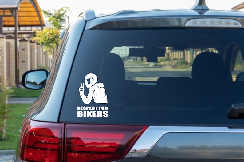 May include: A white vinyl sticker with a silhouette of a motorcyclist wearing a helmet and making a peace sign. The sticker says "Respect for Bikers".