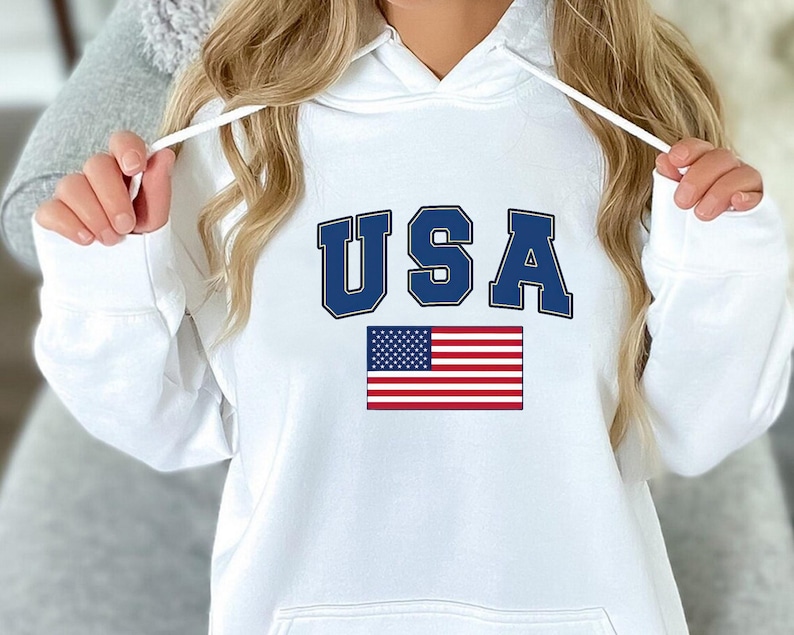 May include: White hoodie with a blue "USA" graphic and an American flag.