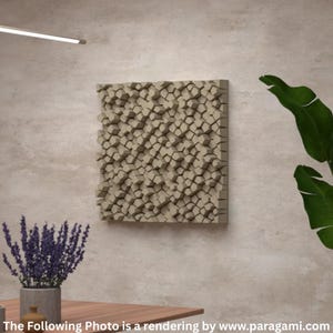 Puede incluir: Un panel acústico beige cuadrado con un diseño geométrico 3D está montado en una pared marrón claro. El panel está compuesto por numerosas formas pequeñas e irregulares. La imagen también muestra una mesa de madera, una planta con flores moradas y una gran hoja verde.