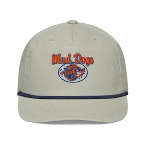 May include: A light gray baseball cap with a navy blue rope brim. The cap features the embroidered text "Mad Dogs" in orange and a blue and orange graphic of a snarling dog.