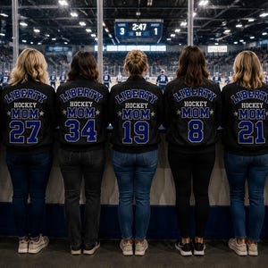 Może przedstawiać: Siedem czarnych kurtek z niebieskimi napisami i numerami na plecach. Każda kurtka posiada napis LIBERTY HOCKEY MOM z unikalnym numerem poniżej, od 7 do 34. Kurtki są noszone przez siedem osób stojących w rzędzie.