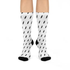 May include: White socks with a black lightning bolt pattern. The socks have black heels and toes. The lightning bolt design is repeated across the entire sock.