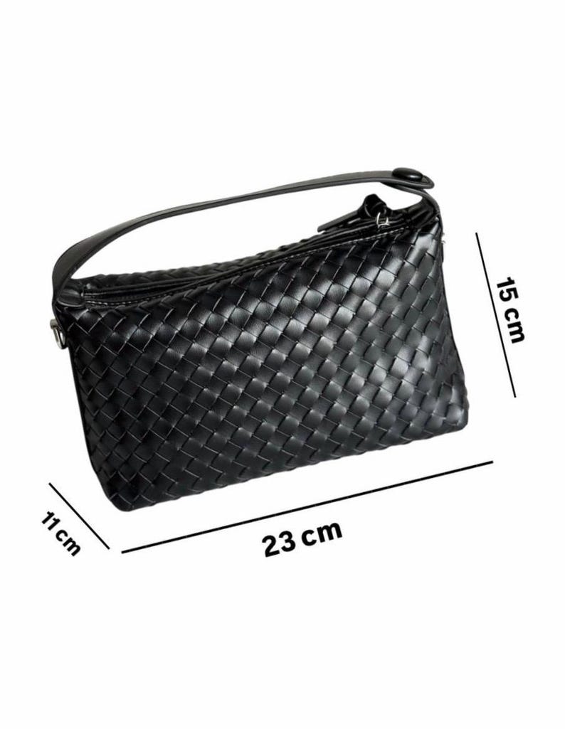 May include: Black woven handbag with a handle. The bag is rectangular, measuring 9 inches long, 6 inches high, and 4 inches wide. The bag has a zipper closure and a single handle.