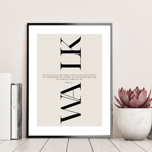Op de afbeelding: Een zwart-witte printbare wandkunstprint met een beige achtergrond. De print bevat het woord "WALK" in grote, vetgedrukte letters met de tekst "Maar als we in het licht wandelen, zoals Hij in het licht is, hebben we gemeenschap met elkaar, en het bloed van Jezus Christus, zijn Zoon, reinigt ons van alle zonde. 1 Johannes 1:7" in kleinere tekst eronder.