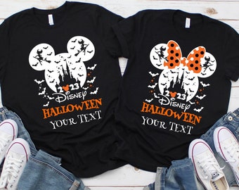 May include: Two black t-shirts featuring a white Mickey Mouse and Minnie Mouse silhouette design. The shirts include a white castle, bats, and the text "2023 Disney Halloween Your Text".