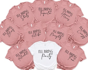 May include: Set of nine pink and white t-shirts with black text. The shirts say "I'll bring the..." followed by words like "bling", "shots", "tequila", "dance moves", "alibi", "naughty", "crazy", "alcohol", "party", and "fun".
