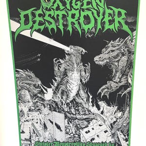 May include: Black patch with green border featuring the text "OXYGEN DESTROYER" in a jagged font. The image depicts a monster destroying a city, with flames and other monsters. Text at the bottom reads "Sinister Monstrosities Spawned by the Unfathomable Ignorance of Humankind."