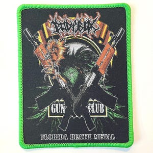 以下が含まれることがあります： 白い文字で「Cannibal Corpse」というバンド名が書かれた黒と緑の刺繍パッチ。パッチには、2丁の銃が交差しており、「Gun Club」と「Florida Death Metal」という文字が白い文字で書かれている。