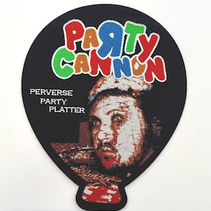 Op de afbeelding: Een zwart-witte geborduurde patch in de vorm van een ballon met de tekst "PARTY CANNON" in kleurrijke letters. De tekst "PERVERSE PARTY PLATTER" staat onder de ballon. Een bloedig gezicht bevindt zich in de ballon.
