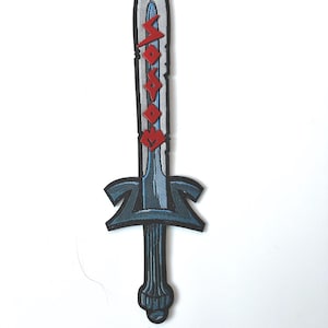 May include: Embroidered patch of a sword with a silver blade, blue accents, and a black handle. The blade has red lettering. The patch is likely for clothing or accessories, adding a unique touch to apparel.