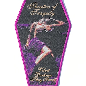 May include: Embroidered patch in a coffin shape with a black background and a purple border. The patch features a figure in a purple dress with the text "Theatre of Tragedy" and "Velvet Darkness They Fear" in gold script.