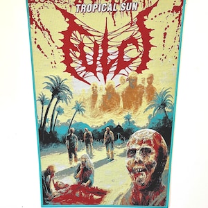 Può includere: Un arazzo rettangolare tessuto con un'illustrazione grafica di zombie in un ambiente tropicale con palme e un edificio. Il testo TROPICAL SUN è stampato in bianco in alto. Il design include schizzi di sangue rosso e un grande logo rosso.