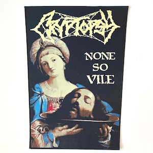 Puede incluir: Parche bordado en negro y dorado con un logotipo de banda y el texto "NONE SO VILE". El logotipo es una fuente estilizada con un diseño gótico. El parche presenta una pintura de una mujer sosteniendo una cabeza cortada en un cuenco.