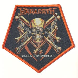 May include: A black, pentagon-shaped patch with an orange border. The patch features a skull with crossed bones, chains, and the band name "MEGADETH" in orange lettering. The text "KILLING IS MY BUSINESS..." is also present.