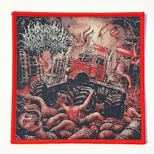 May include: A square woven patch with a red border featuring a detailed graphic of a red truck driving over a pile of human figures in a dark, chaotic scene with a large white tree-like structure and a moon in the background.