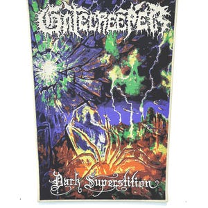 May include: A rectangular patch with the text "Getheheaven" in white, stylized lettering. The patch features a dark, abstract design with green, purple, and orange hues, and the words "Dark Superstition" in a gothic font.