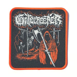 May include: A black, square patch with an orange border. The patch features a Grim Reaper figure in orange, holding a scythe, with the word "Gravekeeper" in white, stylized text. The background includes a graveyard scene with lightning.