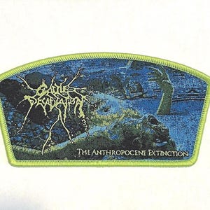 May include: A green and blue embroidered patch with the band name "Battle Decimation" in white lettering and the text "The Anthropocene Extinction" in white lettering.