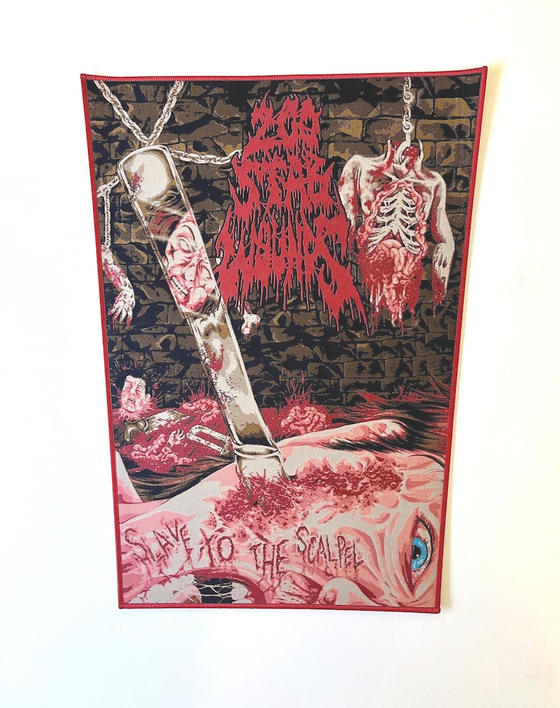Peut inclure: Un patch tiss&eacute; rouge et noir avec le texte "Slave to the Scalpel" et un graphique d'un corps humain ensanglant&eacute; avec un scalpel qui le transperce.
