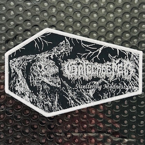 May include: Black and white embroidered patch with a coffin shape. The patch features a detailed illustration of a skeletal figure and the text "GUTWRENCH" above "Sweltering Madness" in a gothic font. The patch has a white border.
