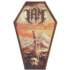 May include: A brown and tan embroidered patch shaped like a coffin with the band name "WOLF" in brown dripping letters. The patch features a sword sticking out of the ground with a skull at the base. The text "SURRENDER TO THE BLADE" is printed in brown at the bottom of the patch.