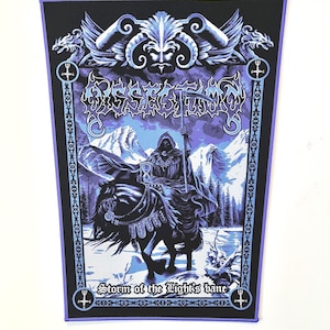 May include: A rectangular black and purple patch featuring a grim reaper riding a horse through a snowy landscape. The patch has the text "Storm of the Light's Bane" and the band's name in a gothic font. The border is purple.