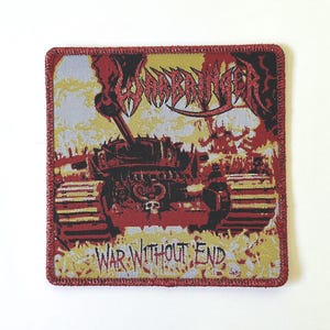May include: Square patch with a red border featuring a tank illustration in red and black. The word "WARBRINGER" is at the top, and "WAR WITHOUT END" is at the bottom, all on a yellow and gray background.