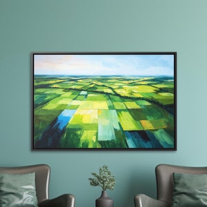 May include: A framed abstract painting of a green and blue landscape with a black frame. The painting is hanging on a teal wall between two gray armchairs with green cushions. A small wooden table with a potted plant sits between the chairs.