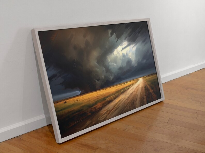 May include: A framed painting depicting a dirt road leading into a field with a dramatic stormy sky overhead. The sky is dark and stormy with a bright light shining through the clouds. The field is a golden yellow color.