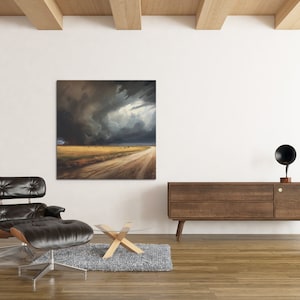 May include: A black leather armchair with a matching ottoman sits in front of a large canvas painting depicting a dramatic stormy sky over a dirt road in a field. A wooden coffee table and a wooden cabinet with a black speaker on top are also in the room.