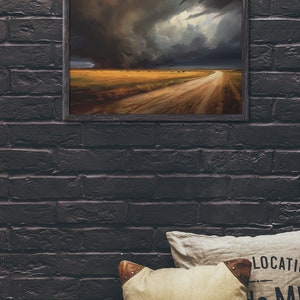 May include: A framed painting of a dirt road leading into a field with a dramatic stormy sky in the background.