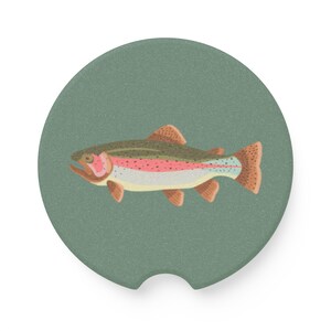 May include: A circular car coaster with a sage green background featuring a detailed illustration of a rainbow trout. The fish has a dark olive back, a vibrant pink lateral stripe, a white underbelly, and speckled brown fins and tail.