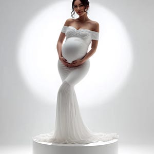 May include: A white off-the-shoulder maternity gown with a mermaid silhouette. The dress features a fitted bodice, a flowing skirt, and a train. The model is standing on a white pedestal in front of a bright white background.