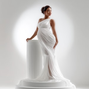 May include: A white, one-shoulder gown with a flowing, pleated design. The dress features a high slit and a long train. The model is standing on a white pedestal next to a white column. The overall theme is maternity fashion.