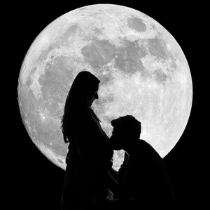 May include: A black and white silhouette of a pregnant person and a person kissing their belly, with a large full moon in the background. The image highlights the figures against the moon's bright surface and the dark sky.