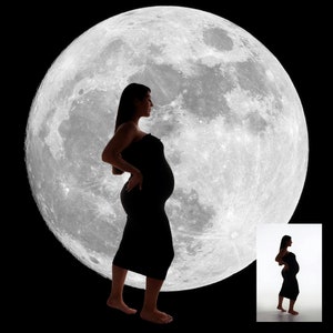 May include: A black silhouette of a pregnant person in a dress, set against a large, bright full moon. The image is on a black background, with a smaller version of the image in the bottom right corner.