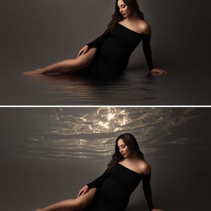 May include: A woman wearing a black off-the-shoulder dress with long sleeves, sitting in water. The dress has a thigh-high slit. The background is a dark gray, with the water reflecting the light. The woman has long, dark hair.
