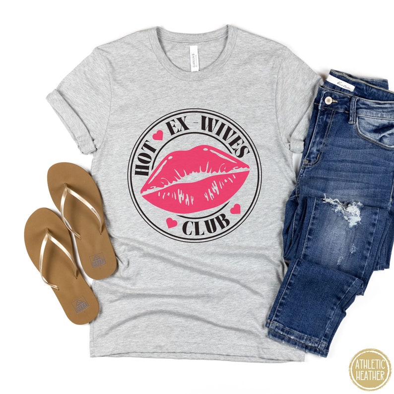 May include: Grey t-shirt with a black circle graphic that says "Hot Ex-Wives Club" with a pink lipstick print inside the circle.