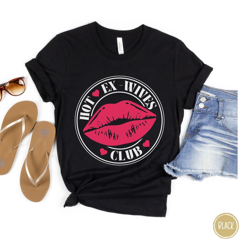 May include: Black t-shirt with a white circle graphic that says "Hot Ex-Wives Club" with a red lip print inside the circle.